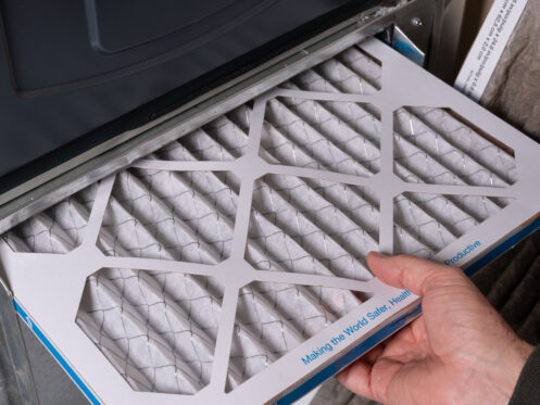 Man replacing dirty furnace filter in home